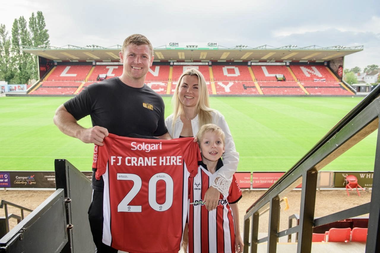 FJ Crane Hire team members at football stadium sponsorship event