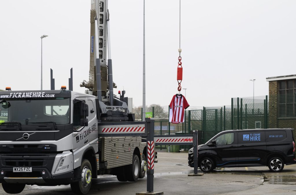 Compact crane lifting load in industrial yard