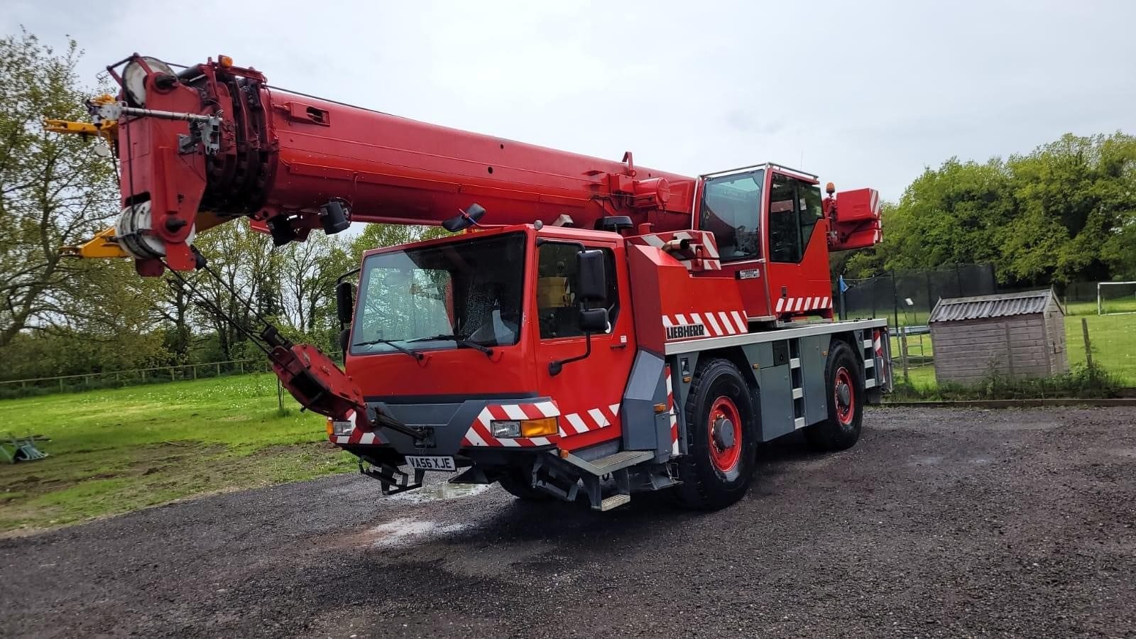 Red FJ Crane Hire mobile crane parked on site