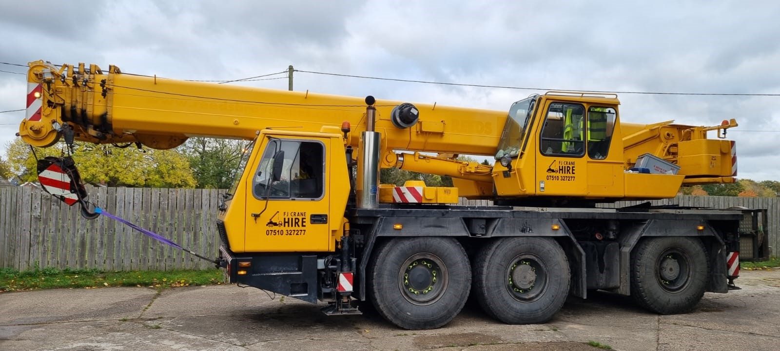 Yellow crane vehicle parked on industrial site
