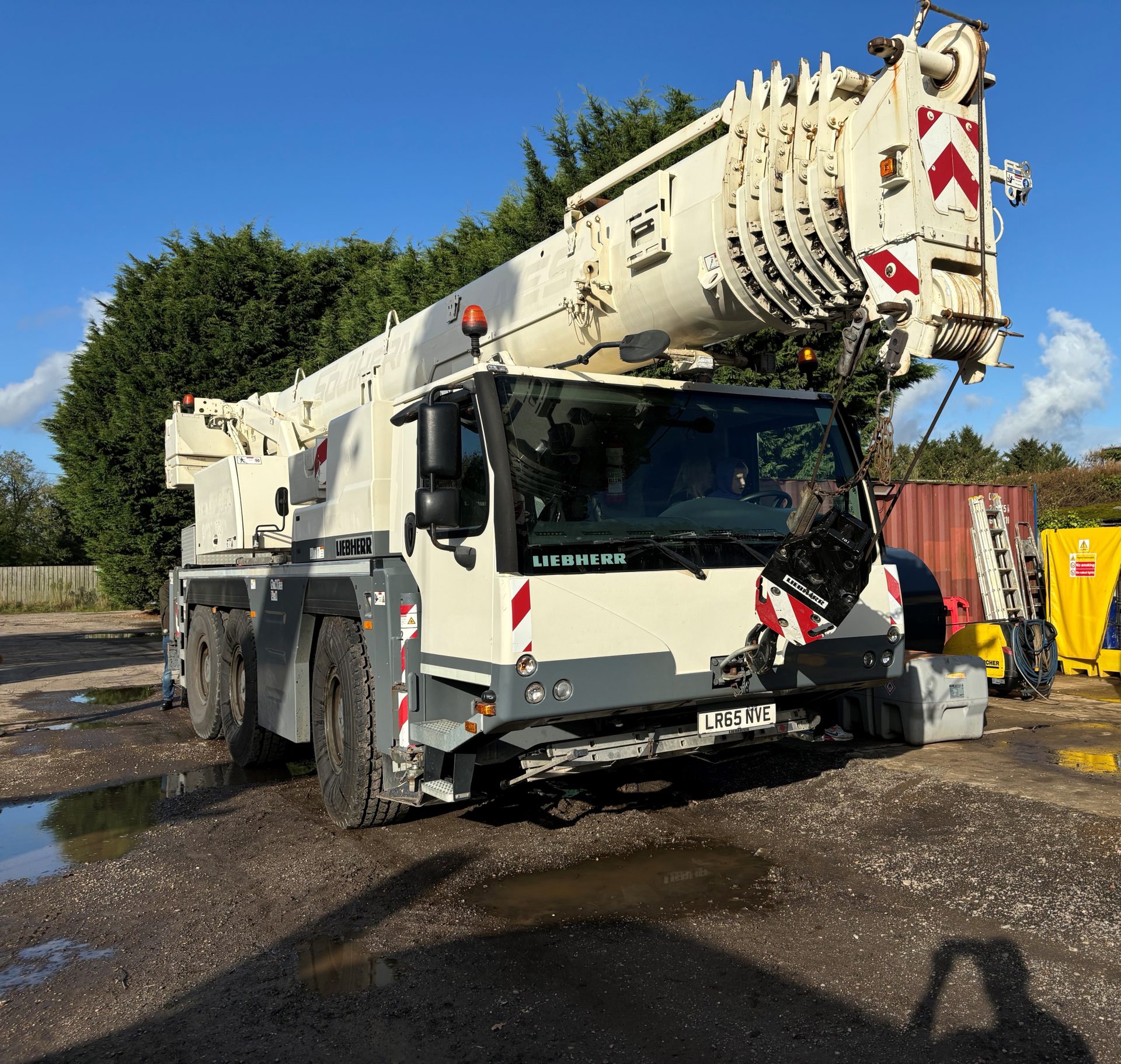 White heavy-duty mobile crane parked outdoors
